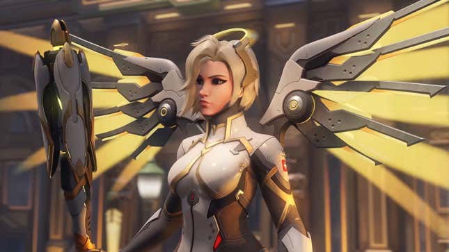 Mercy is shown standing with her staff in hand and mechanical wings spread.
