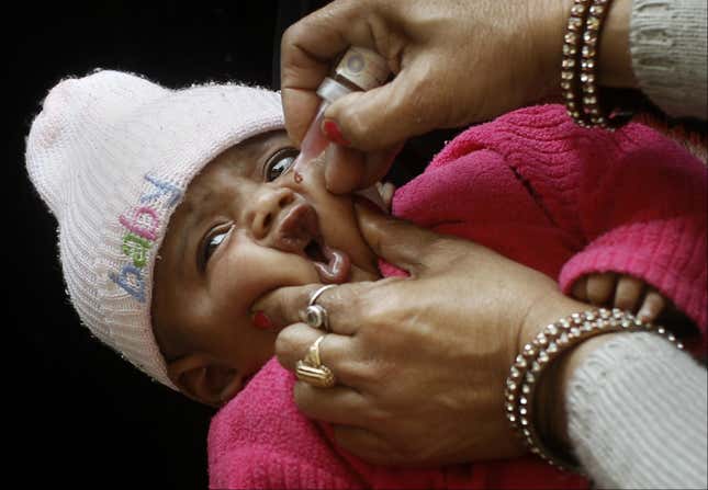 A young Indian girl is given her first polio vaccination. AP Photo/Kevin Frayer