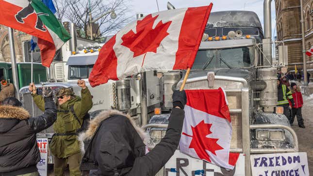 OTTAWA, ON - JANUARY 30: A woman waves a flag and cheers on truckers in protest of COVID-19 vaccine mandates on January 30, 2022 in Ottawa, Canada. Thousands turned up over the weekend to rally in support of truckers using their vehicles to block access to Parliament Hill, most of the downtown area Ottawa, and the Alberta border in hopes of pressuring the government to roll back COVID-19 public health regulations.