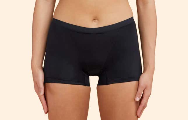 A model wears a pair of black Thinx boyshorts