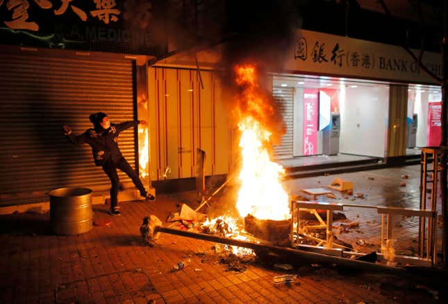 A rioter tries to throw bricks at police in the Mong Kok district of Hong Kong, Feb. 9, 2016, during the Lunar New Year holiday.