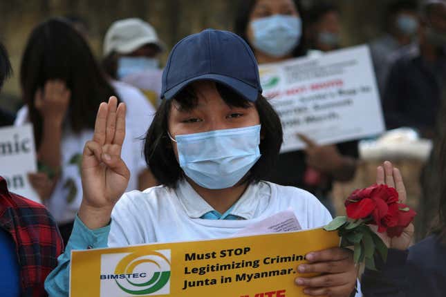 Myanmar citizens living in India flash the three-finger salute as they participate in a protest against the military coup in February 2022.