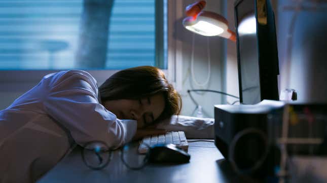 Woman sleeping at her desk in front of computer 