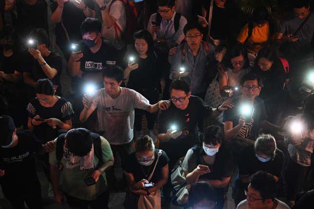 Mobile phones illuminate the scene.