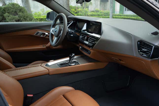 El interior del concept car BMW Shooting Brake visto a través de la apertura de la puerta del lado del pasajero.  Es mayormente marrón con cuero gris en el tablero.