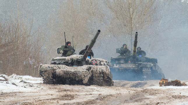 Men are in tanks with weapons on top of them.