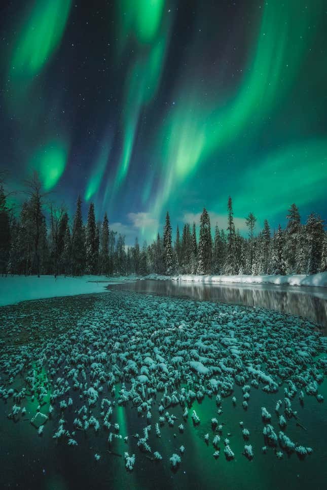 A frozen water body beneath the aurora in Finland.