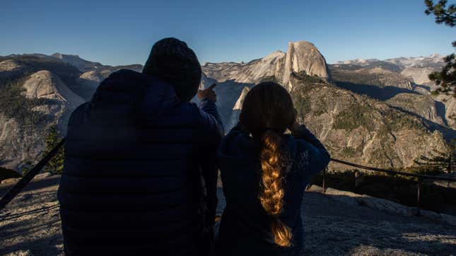 Visitors at Yosemite National Park look at Half Dome.