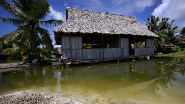 An abandoned house that is affected by seawater during high-tides stands next to a small lagoon near the village of Tangintebu on South Tarawa in the central Pacific island nation of Kiribati May 25, 2013. Kiribati consists of a chain of 33 atolls and islands that stand just metres above sea level, spread over a huge expanse of otherwise empty ocean. With surrounding sea levels rising, Kiribati President Anote Tong has predicted his country will likely become uninhabitable in 30-60 years because of inundation and contamination of its freshwater supplies. Picture taken May 25, 2013. REUTERS/David Gray