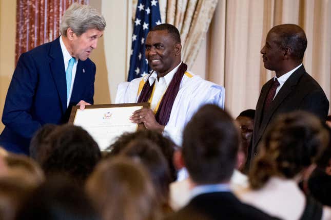 US Secretary of State John Kerry with anti-slavery activist Biram Dah Abeid, center, and Brahim Bilal Ramdhane, right, of Mauritania as they are recognized as "2016 Trafficking in Persons Report" heroes, whose efforts have made an impact on the global fight against modern slavery, Thursday, June 30, 2016, during a news conference for the report in the Ben Franklin Room of the State Department in Washington.