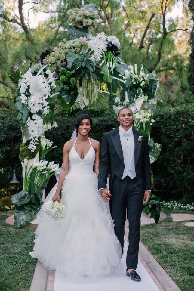 Russell Westbrook walks down the aisle with his bride Nina Earl during their outdoor wedding ceremony at the Beverly Hills Hotel