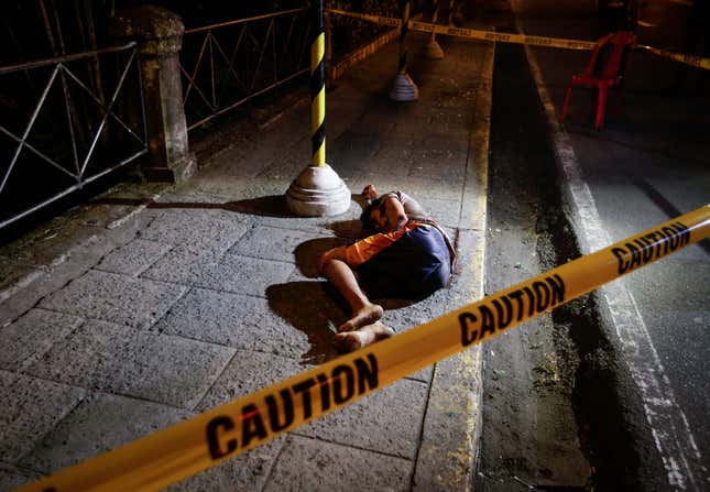 A man allegedly involved in drug dealing or consumption lies on a street after being shot down by an unidentified gunman in Intramuros, Manila, Philippines, on Dec. 24, 2016.