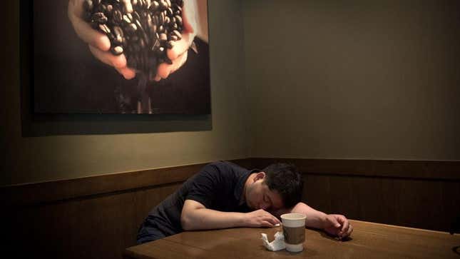 Man sleeping next to coffee cup