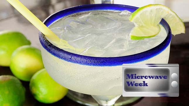 Margarita in a glass with salted rim beside some limes