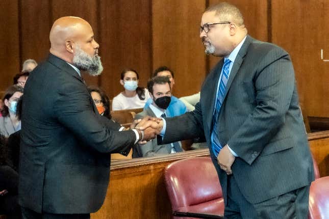 Steven Lopez, left, shake hands with Manhattan District Attorney Alvin Bragg, right, during a court hearing, Monday, July 25, 2022, in New York. Lopez, a co-defendant of the so-called Central Park Five, whose convictions in a notorious 1989 rape of a jogger were thrown out more than a decade later, had his conviction on a related charge overturned Monday. 
