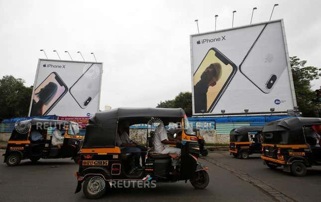 Auto-rickshaws drive past the hoardings of Apple iPhone X mobile phones in Mumbai, India July 27, 2018. Picture taken July 27, 2018. REUTERS/Francis Mascarenhas – RC17915BE420