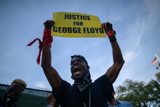 A Black Lives Matter (BLM) protester holds a placard and shouts slogans during a march on the anniversary of the death of George Floyd, in Brooklyn, New York, on May 25, 2021. - The family of George Floyd appealed on May 25 for sweeping police reform on the anniversary of the African American man’s murder by a white officer, as they met President Joe Biden at the White House. 