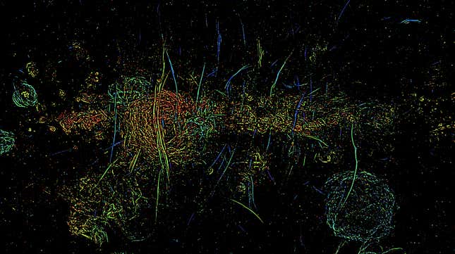 A multi-colored image shows long vertical streaks of magnetic filaments in the Milky Way's core.