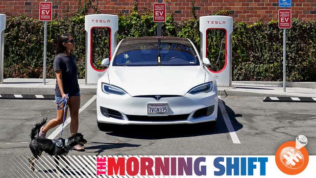 A bystander walks a dog in front of a Tesla parked outside a store in California.