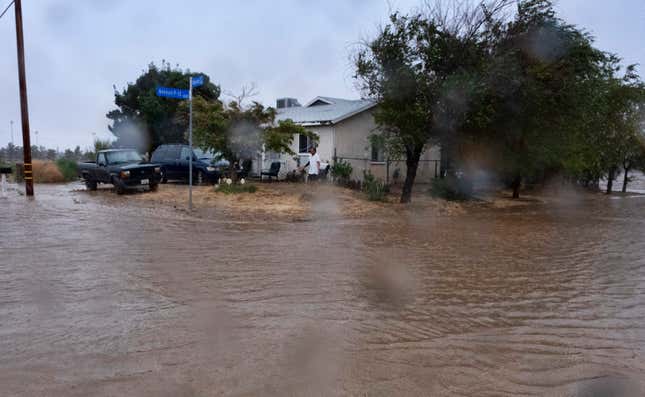 A resident checks the floodwaters surrounding his home during a downpour in Palmdale, California, as Tropical Storm Hilary moves into the area on Sunday, August. 20, 2023.