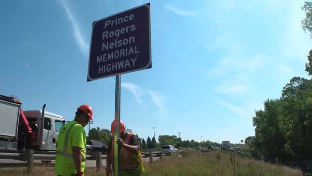 MNDOT workers installed a purple Prince Rogers Nelson Memorial Highway sign