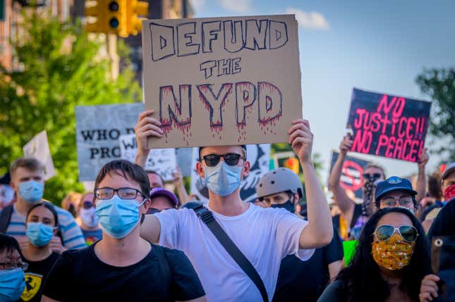 A counterprotester holding a Defund Police sign at the protest. Pro-NYPD marchers clashed with a big crowd of Black Lives Matter counterprotesters during the Back the Blue rally and march in Bay Ridge, Brooklyn.