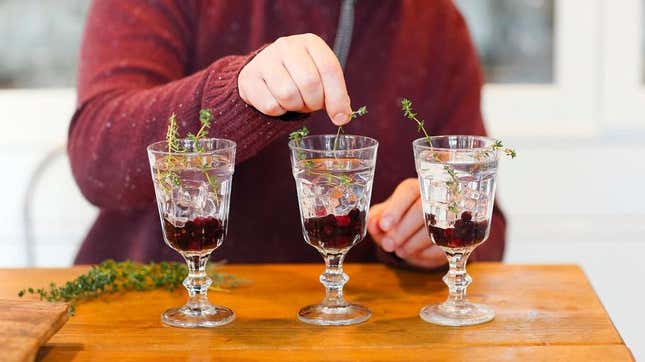 Person assembling cocktails at home in three glasses