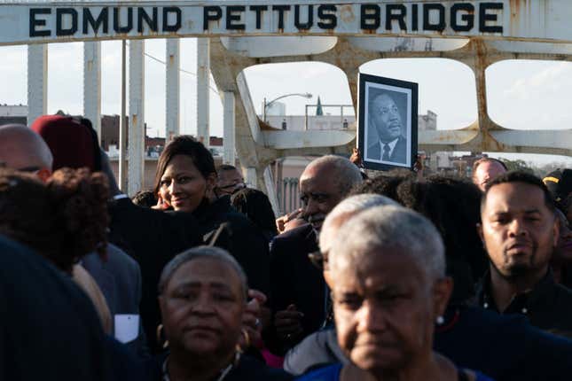 A person holds up a photo of the late Reverend Martin Luther King Jr. marching across the Edmund Pettus Bridge in commemoration of the 57th anniversary of ‘Bloody Sunday’ in Selma, Alabama, on March 6, 2022.