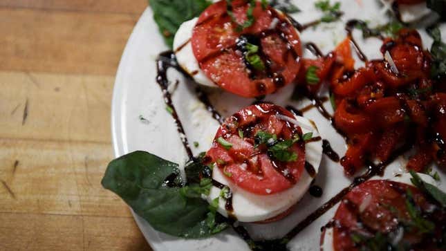Caprese (tomato, mozzarella, basil, balsamic drizzle) plated and ready to be served