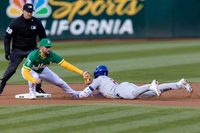 Apr 18, 2023; Oakland, California, USA;  Chicago Cubs second baseman Nico Hoerner (2) dives into second for a double against Oakland Athletics shortstop Kevin Smith (4) during the first inning at RingCentral Coliseum.