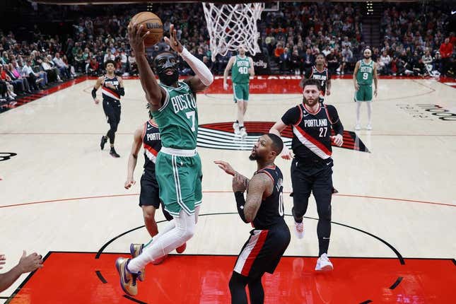 Mar 17, 2023; Portland, Oregon, USA; dBoston Celtics shooting guard Jaylen Brown (7) shoots the ball against Portland Trail Blazers point guard Damian Lillard (0) uring the first half at Moda Center.