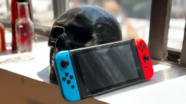A Nintendo Switch sitting by the window in front of a black skull.