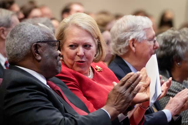  Associate Supreme Court Justice Clarence Thomas sits with his wife and conservative activist Virginia Thomas while he waits to speak at the Heritage Foundation on October 21, 2021, in Washington, DC.