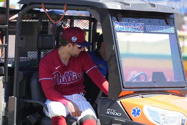 Mar 23, 2023; Clearwater, Florida, USA; Philadelphia Phillies first baseman Rhys Hoskins (17) leaves the game on a medical cart after falling to the ground while trying to field a ball during the first inning at BayCare Ballpark. Hoskins was injured during the play and left the game.