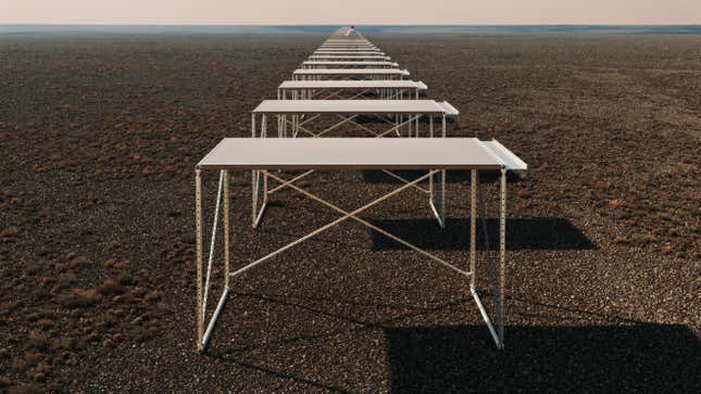 Several of the Teenage Engineering Field Desks sitting in a long row in a barren field.