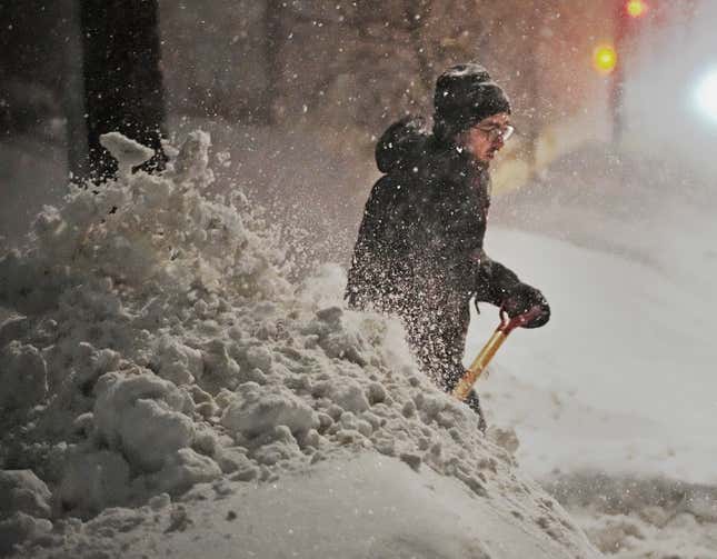 Brian Hedberg clears snow from the alleyway to try and get his car through a plowed snow bank Thursday, Feb. 23, 2023 in Minneapolis, Minnesota. 