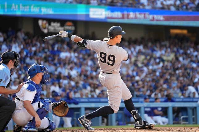 June 3, 2023;  Los Angeles, California, USA;  New York Yankees right fielder Aaron Judge (99) hits a home run in the sixth inning as Los Angeles Dodgers catcher Will Smith (16) and home plate umpire John Tumpen (74) watch at Dodger Stadium.