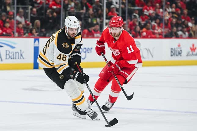 Mar 12, 2023; Detroit, Michigan, USA; Boston Bruins center David Krejci (46) brings the puck up ice against Detroit Red Wings right wing Filip Zadina (11) during the first period at Little Caesars Arena.