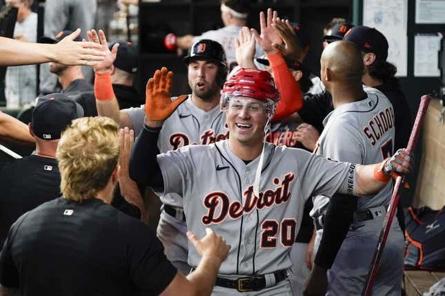 Jun 29, 2023; Arlington, Texas, USA; Detroit Tigers first baseman Spencer Torkelson (20) is greeted in the dugout by teammates and presented with a hockey helmet and stick after hitting a three run home run during the eighth inning against the Texas Rangers at Globe Life Field.