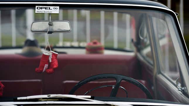 A photo of mini boxing gloves hanging from a rear view mirror. 