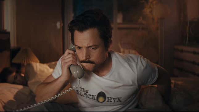 Henk Rogers (Taron Egerton) wears a t-shirt that says The Black Onyx in a scene from the film Tetris.