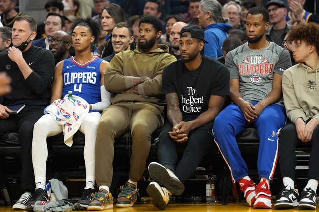 Mar 8, 2022; San Francisco, California, USA; LA Clippers guard Paul George (center, left) and forward Kawhi Leonard (center, right) sit in street clothes on the bench during the second quarter against the Golden State Warriors at Chase Center.