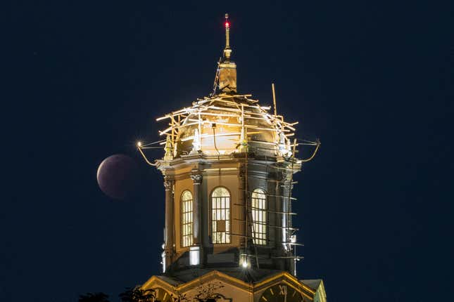 A lunar eclipse occurs beside the clock tower of the Manila City Hall, Philippines, Wednesday, May 26, 2021.