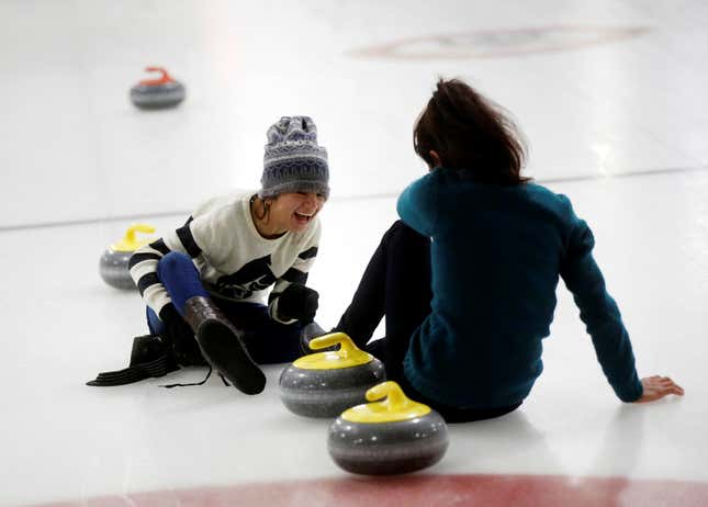 Yazidi refugees from Kurdistan laugh on the ice as they learn the sport of curling in Toronto (Reuters/Mark Blinch)