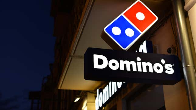 Domino's Pizza sign lit up at night.
