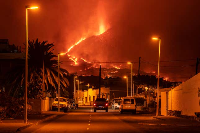 A car drives through an empty street in the neighborhood of La Laguna as lava flows from the Cumbre Vieja Volcano on October 9, 2021 in La Palma, Spain.