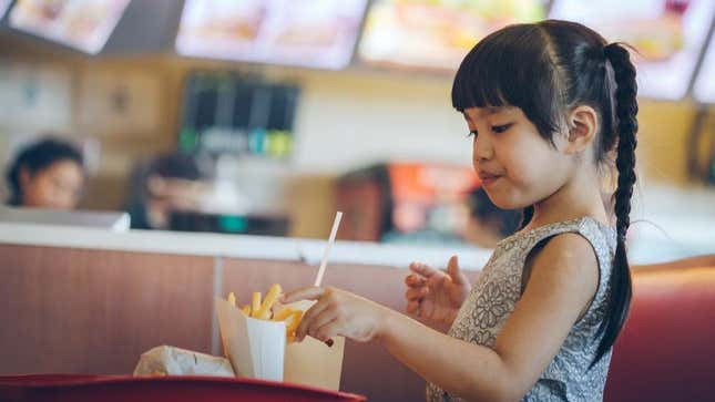 Young girl reaching for french fries