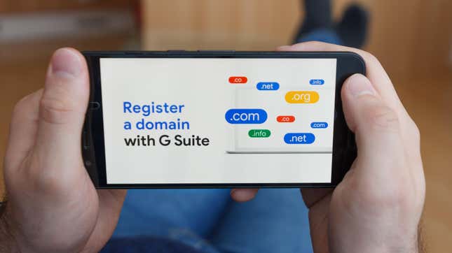Close up to male hands holding smartphone using G Suite application for register a domain