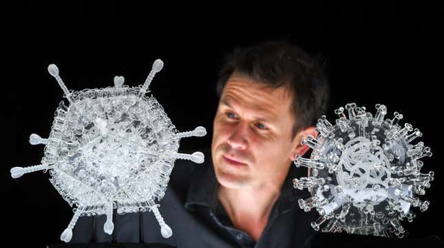 Artist Luke Jerram with his glass sculpture of the Oxford-AstraZeneca coronavirus vaccine, left, alongside his earlier work of the virus itself, in glass at the Paintworks on February 05, 2021 in Bristol, England.