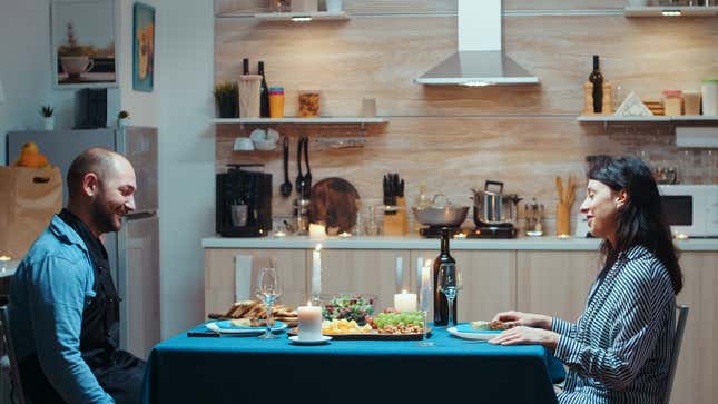 a couple having dinner in their kitchen